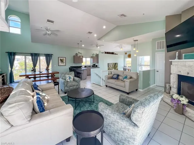 Living room featuring lofted ceiling, visible vents, and ceiling fan