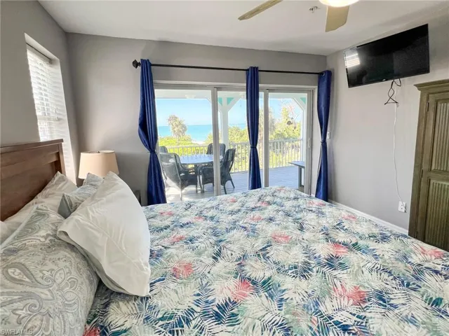 Bedroom featuring ceiling fan, access to outside, multiple windows, and baseboards