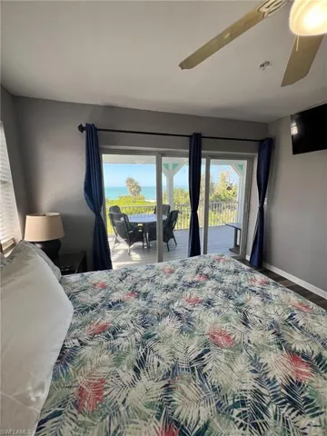 Bedroom featuring access to outside, baseboards, ceiling fan, and wood finished floors