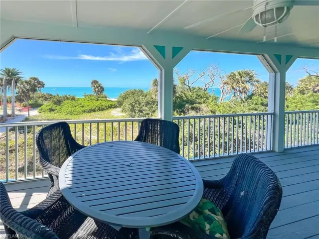 Deck with a water view, a ceiling fan, and outdoor dining space