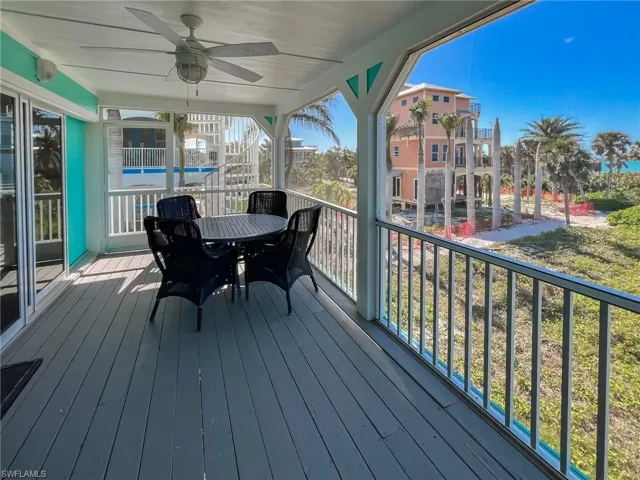 Wooden deck featuring ceiling fan and a carport