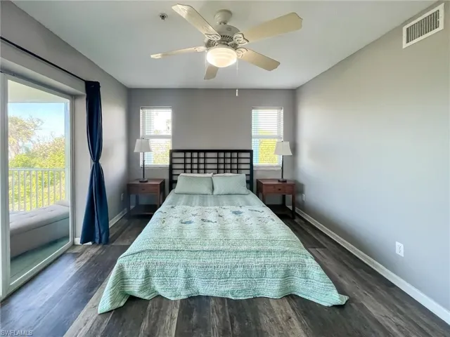 Bedroom featuring dark wood-style floors, visible vents, baseboards, and a ceiling fan