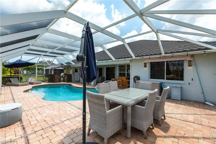View of swimming pool featuring a patio and glass enclosure