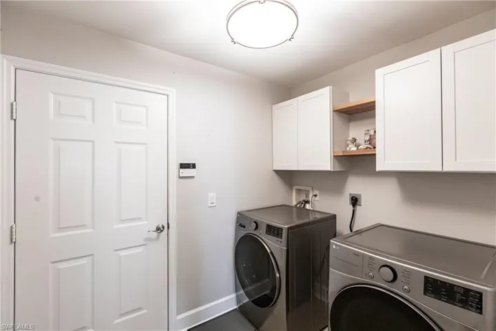 Washroom featuring electric dryer hookup, washer and clothes dryer, cabinets, and hookup for a washing machine