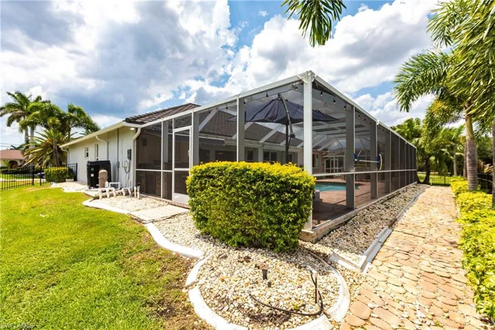 Back of house with a patio, a yard, a lanai, and a fenced in pool