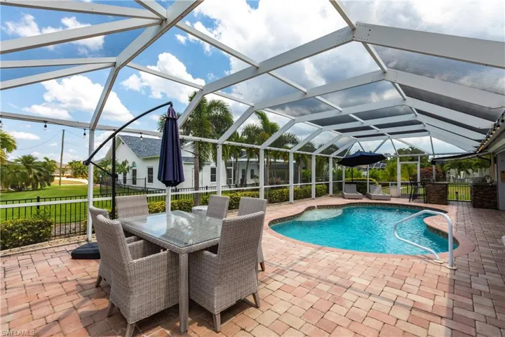 View of pool with a patio and glass enclosure
