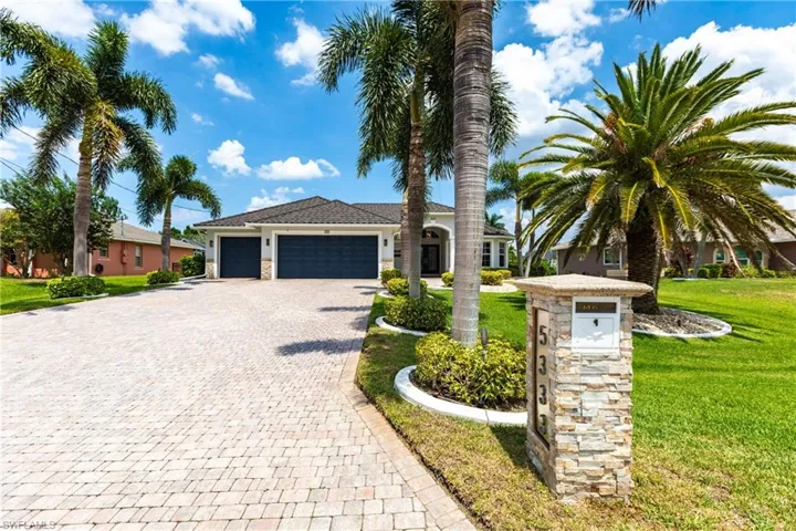 View of front facade featuring a front yard and a garage