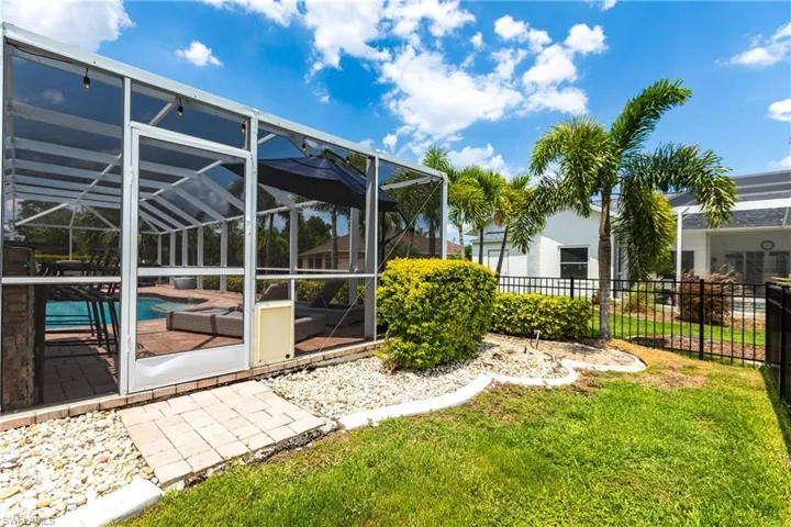 View of yard featuring glass enclosure and a fenced in pool