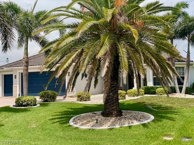 View of front of home featuring a garage and a front lawn
