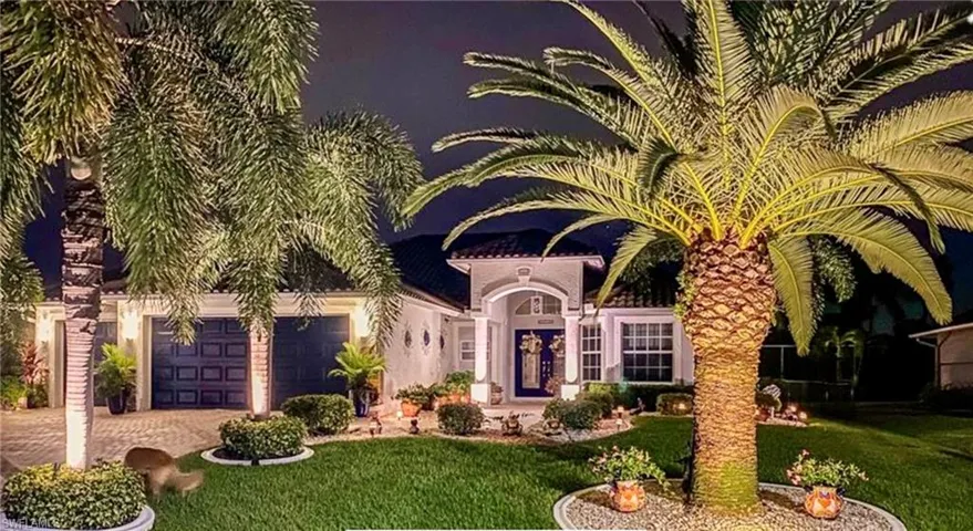 View of front of property featuring a garage and a front lawn