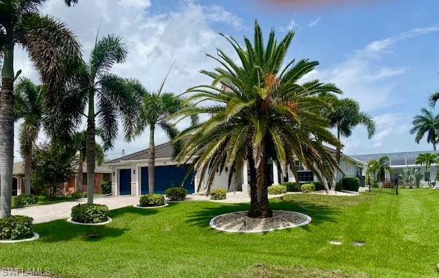 View of front facade featuring a garage and a front yard