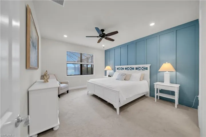 Bedroom featuring a decorative wall, light colored carpet, recessed lighting, and a ceiling fan