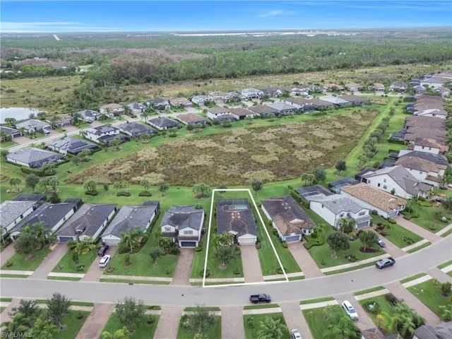 Aerial view of property and surrounding area with nearby suburban area and property boundaries highlighted