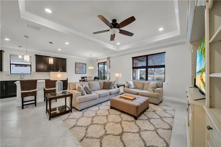 Living room with ornamental molding, plenty of natural light, a ceiling fan, and recessed lighting
