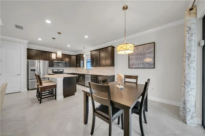 Dining room with crown molding and recessed lighting