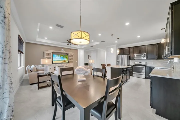 Dining space featuring ornamental molding, recessed lighting, and a raised ceiling