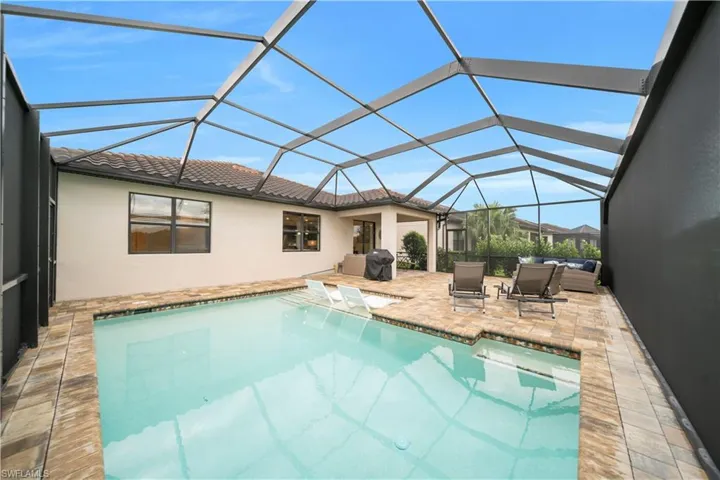 Swimming pool featuring a sunroom, a lanai, a patio area, and a grill