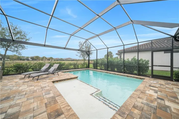 Swimming pool with a lanai, a sunroom, and a patio area