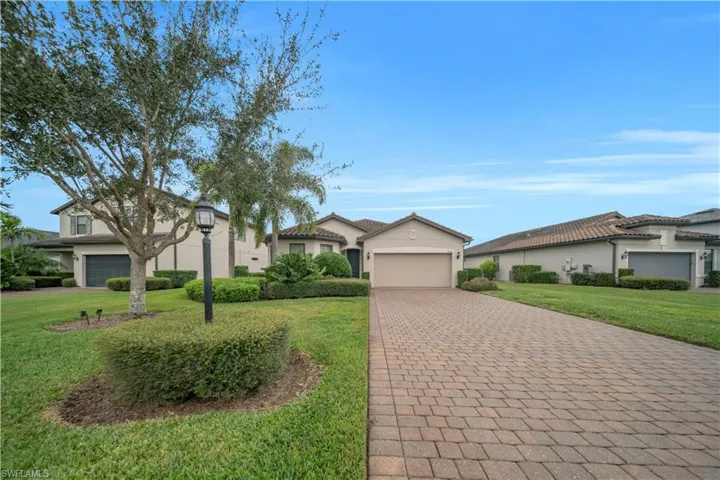 Mediterranean / spanish home with decorative driveway, stucco siding, a front yard, and a garage