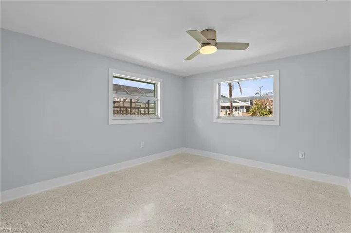 Bedroom with baseboards and a ceiling fan and terrazzo floor.  Virtually edited image.