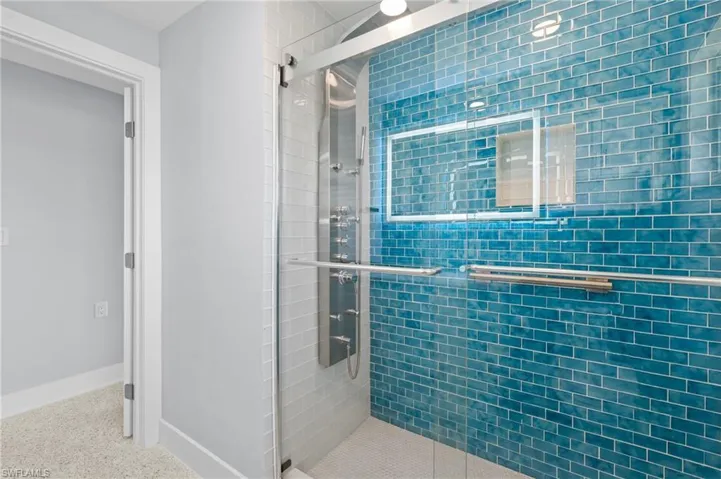 Bathroom featuring terrazzo floor, baseboards, and a stall shower. Virtually edited image.