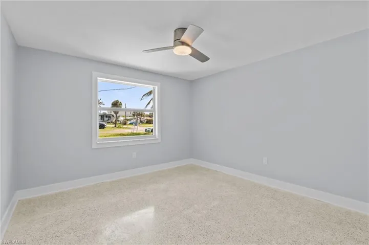 Bedroom featuring ceiling fan, terrazzo floor, and baseboards / vrtually edited photo.
