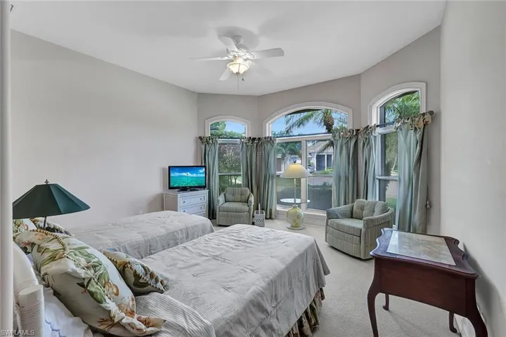 Bedroom with ceiling fan and light carpet