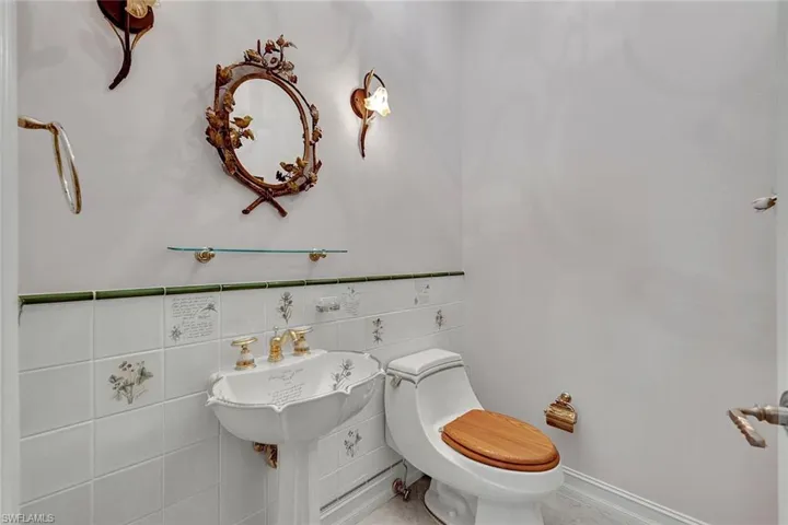 Bathroom with tile walls, toilet, and tile patterned flooring