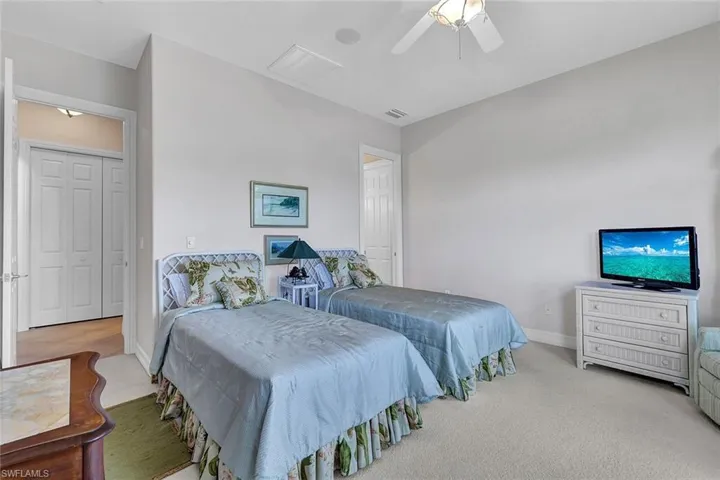 Carpeted bedroom featuring a closet and ceiling fan