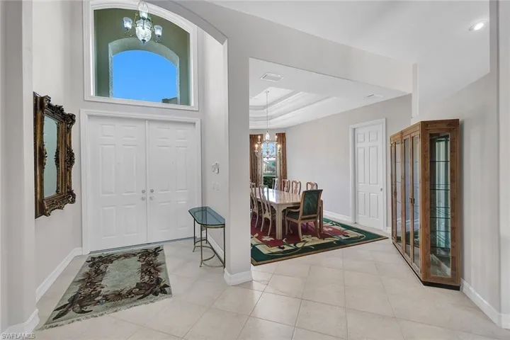 Entrance foyer featuring a raised ceiling, an inviting chandelier, and tile patterned flooring