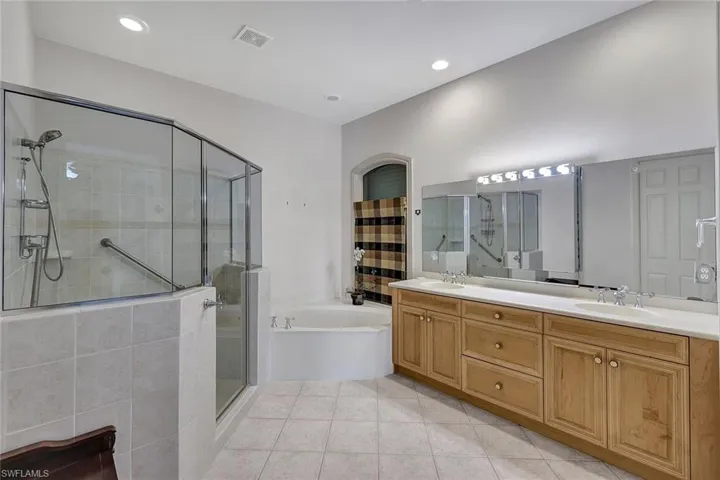Bathroom with shower with separate bathtub, tile patterned floors, and dual bowl vanity