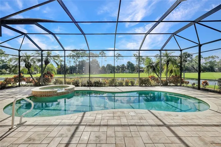 View of pool featuring an in ground hot tub, a patio, and glass enclosure