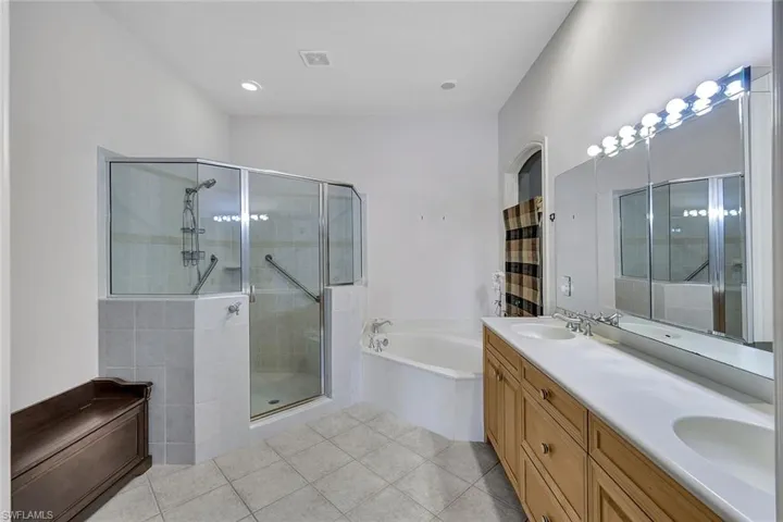 Bathroom with plus walk in shower, dual vanity, and tile patterned flooring