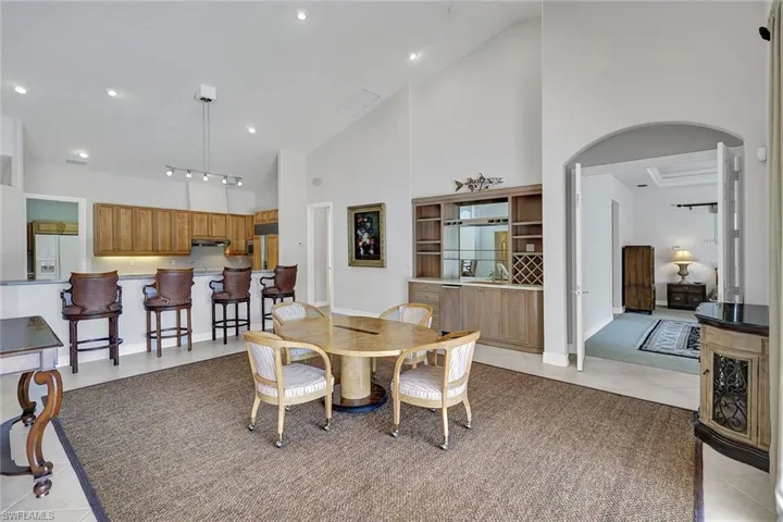 Dining room featuring light tile patterned floors, high vaulted ceiling, and rail lighting
