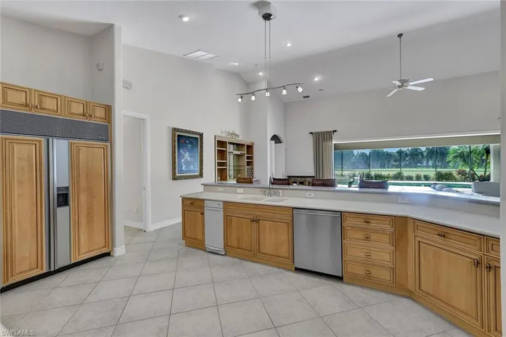 Kitchen featuring dishwasher, high vaulted ceiling, paneled fridge, and stainless steel dishwasher