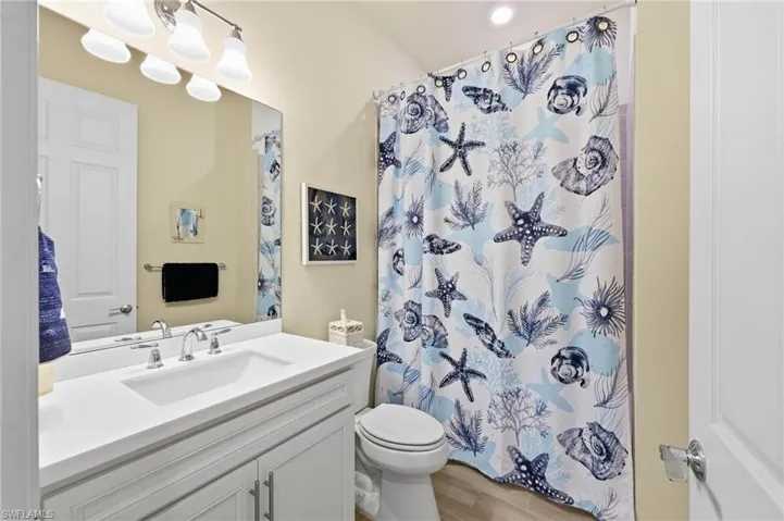Bathroom #2 featuring a white vanity with tub and shower
