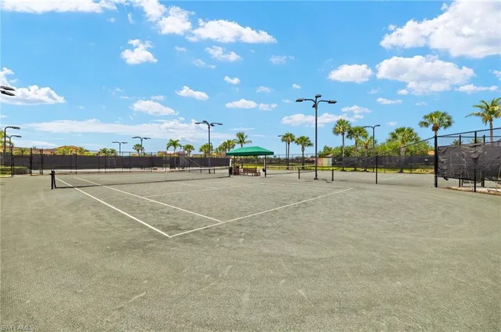 View of tennis court featuring fence