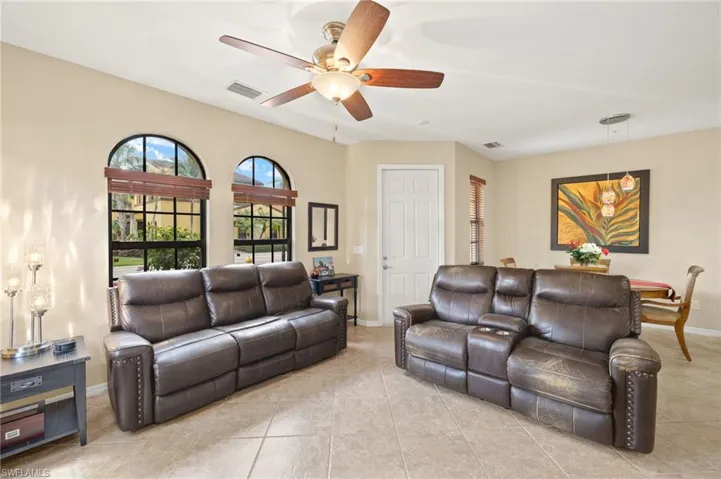 Living room featuring ceiling fan, baseboards, and light tile patterned floors