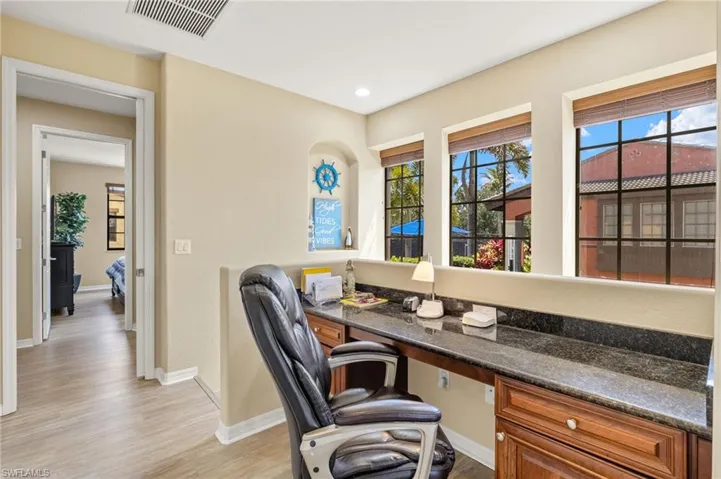 Office featuring light wood finished floors, built in study area, baseboards, and recessed lighting