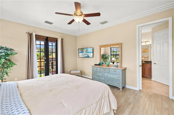 Bedroom with multiple windows, access to exterior, light wood-type flooring, ornamental molding, and a ceiling fan