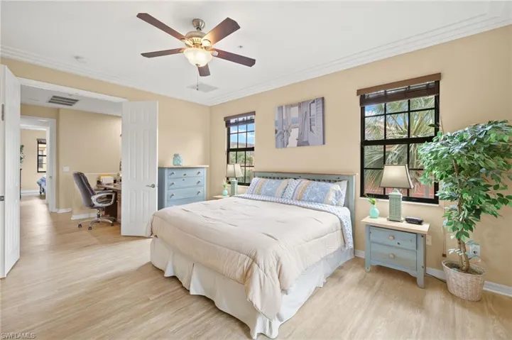 Bedroom with light wood-style flooring, an office area, ornamental molding, baseboards, and a ceiling fan