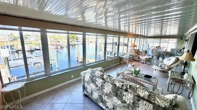 Sunroom with a water view and tile patterned flooring