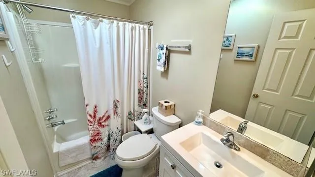 Bathroom with shower / bath combo with shower curtain and vanity