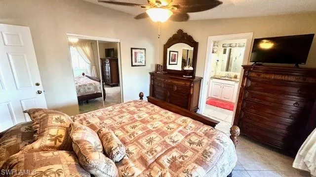 Bedroom with light tile patterned floors, a closet, a ceiling fan, and a textured ceiling