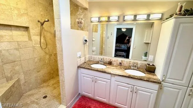 Full bathroom with double vanity and tiled shower