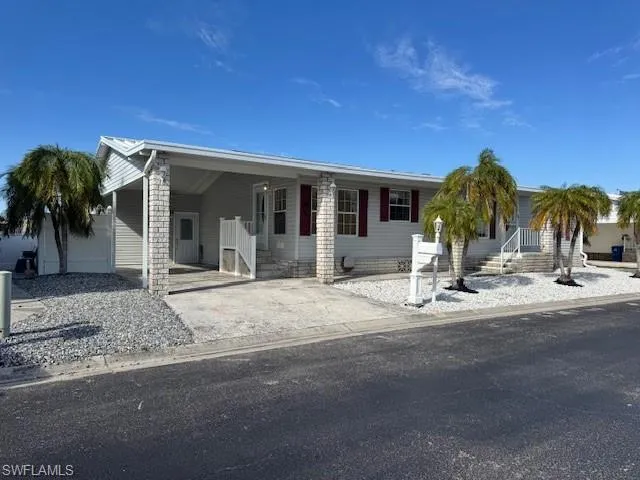 View of front of property with an attached carport and concrete driveway