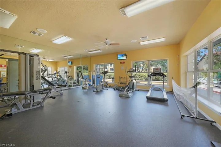Workout area with ceiling fan and a textured ceiling