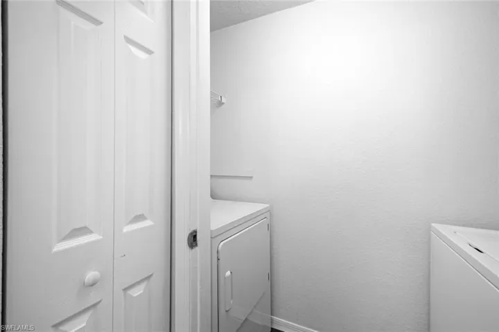 Washroom featuring a textured ceiling and separate washer and dryer
