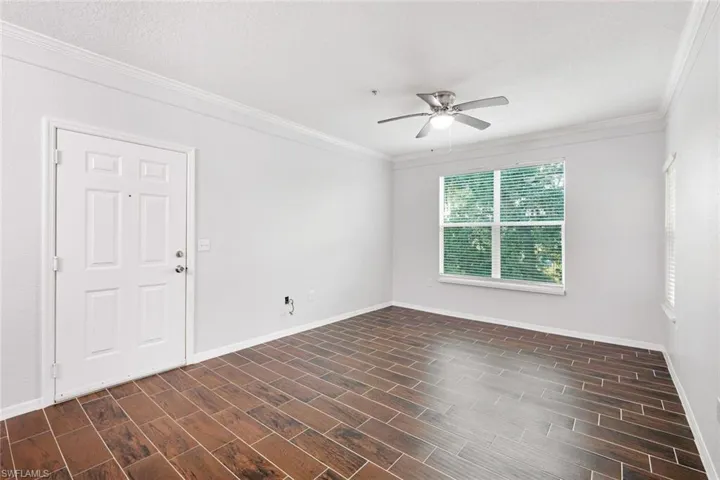 Unfurnished room with crown molding, a textured ceiling, ceiling fan, and dark hardwood / wood-style flooring