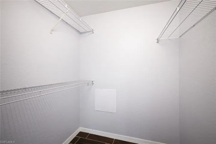 Spacious closet featuring dark tile patterned flooring